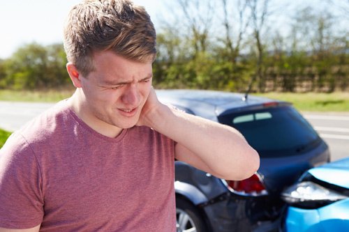 Man Experiencing Whiplash After Car Collision