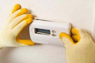HVAC Technician repairing a thermostat — Air Conditioning Services in Dumfries, VA