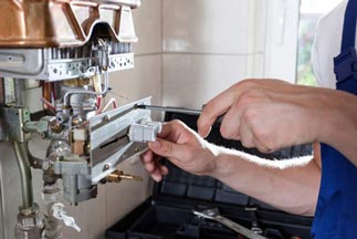 HVAC Technician adjusting gas water heater — Brands and Services in Dumfries, VA