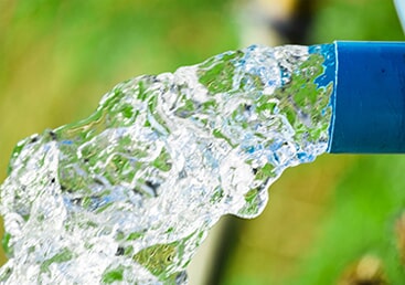 Well Installation — Blue Pump Pipe With Water Flowing in Hardy, VA